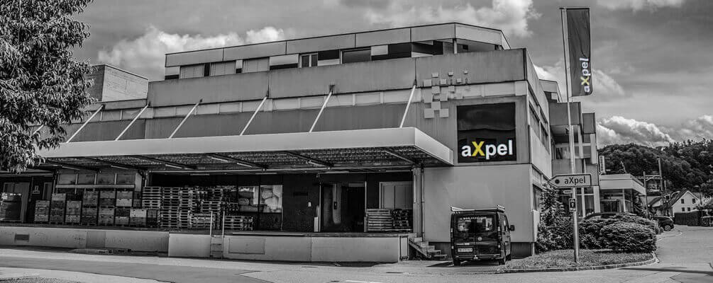 The aXpel building in Burgdorf, with the company sign and flag.